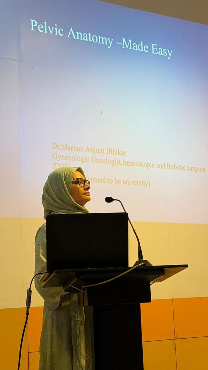 Dr. Mariam Anjum at podium — side view during Pelvic Anatomy talk